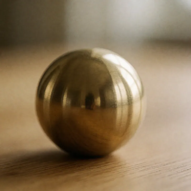 A brass paperweight on an oak table